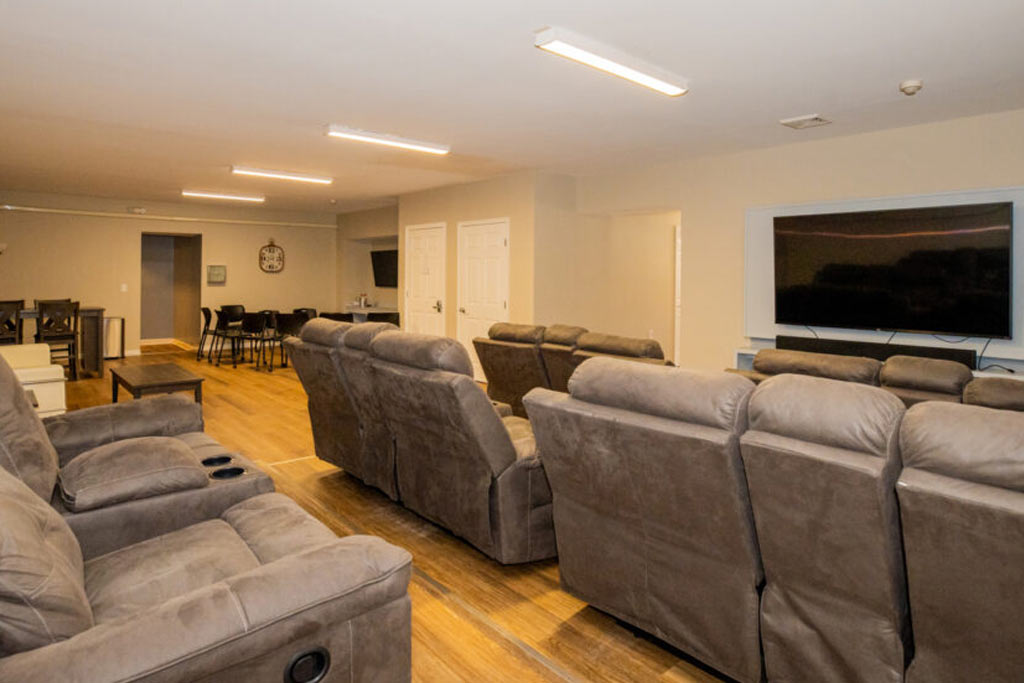 Group and recreational therapy room with recliner seating and large screen at Silver Pines detox and residential treatment center for addiction and mental health disorders.
