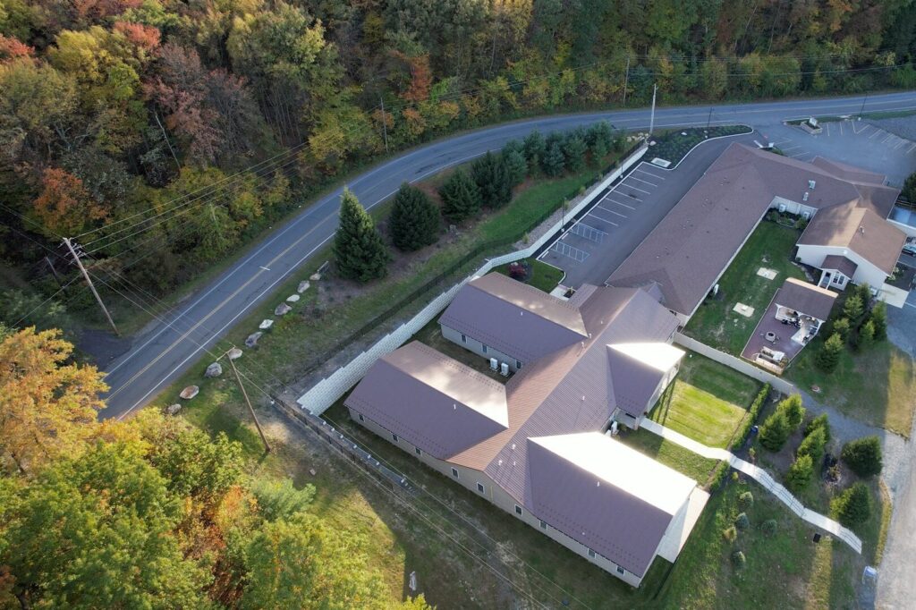 Aerial drone view of the back of STR Behavioral Health’s Silver Pines facility, a treatment center for addiction and mental health, surrounded by a serene and therapeutic natural landscape that supports healing and recovery.
