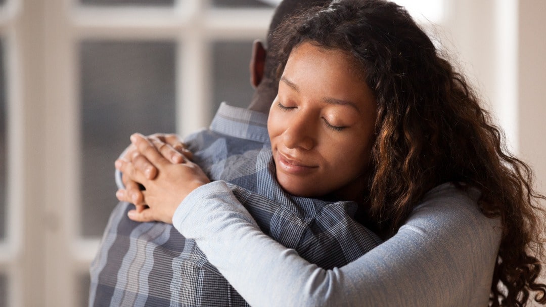 Woman hugging a man in support.