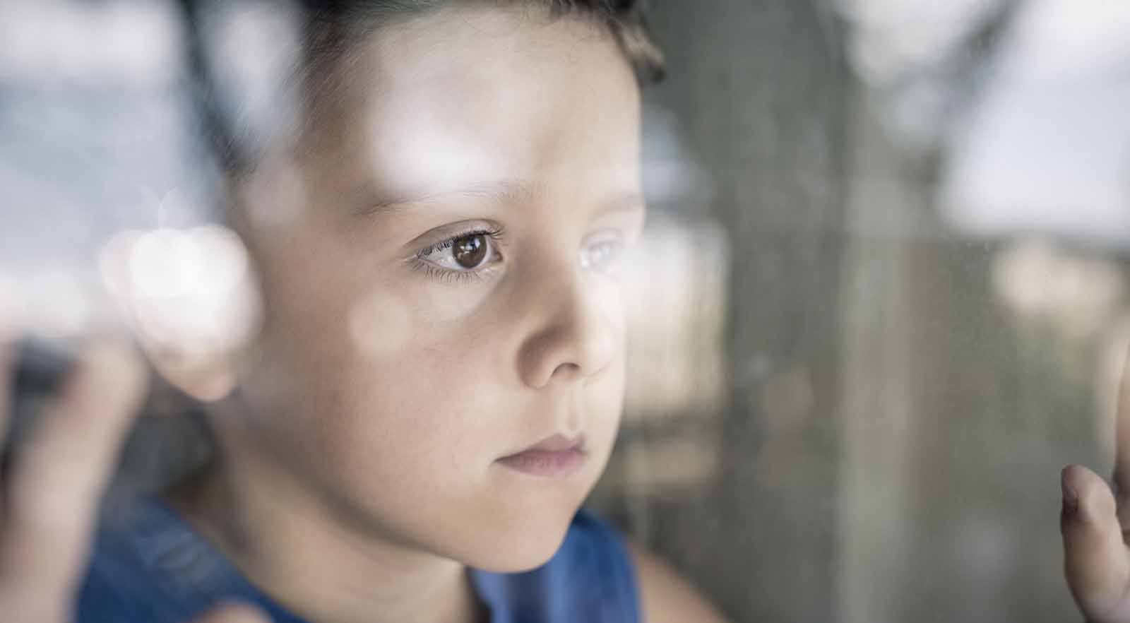 sad-little-boy-looking-out-window
