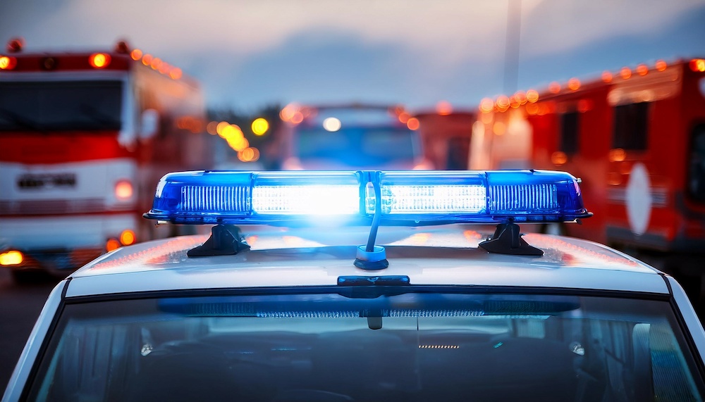 close up of blue light flasher on roof of ambulance car of emergency medical service on road against fire engines themes rescue accidents and disasters